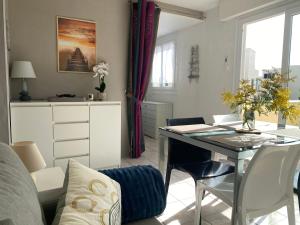 a living room with a table and a couch at Appartement Grand Large - 3 pièces - 5 couchages in Le Barcarès