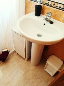 Un baño con un lavabo blanco en una habitación. en Casa Luna, en Santiago de la Ribera