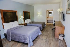 a hotel room with two beds and a desk at Hotel Villa del Sol in Ciudad Juárez
