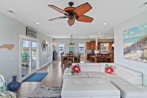a living room with a white couch and a ceiling fan at Hakuna Matata by Sea Scape Properties in North Topsail Beach
