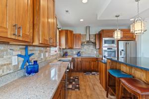 a kitchen with wooden cabinets and a counter top at Hakuna Matata by Sea Scape Properties in North Topsail Beach