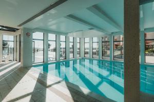 a large swimming pool in a building with windows at Real Marina Hotel & Spa in Olhão