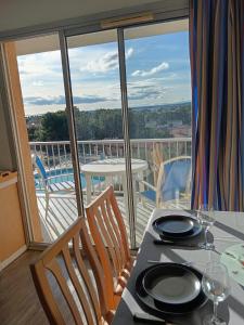 a dining room with a table and chairs and a balcony at Chez Laurette in Balaruc-les-Bains