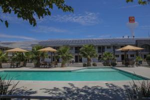 a pool in front of a building with a basketball court at Hotel Villa del Sol in Ciudad Juárez