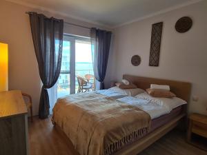 a bedroom with a bed and a sliding glass door at AF Panorama Lux in Siófok