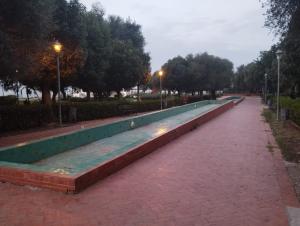 a long bench on a sidewalk in a park at Casa Youssef 1 in Asilah
