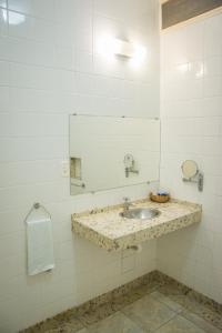 a bathroom with a sink and a mirror at Grande Lago Hotel Gastronomia Bar in Três Marias
