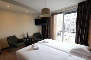 Postel nebo postele na pokoji v ubytování Stadshotel Doesburg