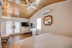 een slaapkamer met een bed, een plafondventilator en een bureau bij Custom House Inn All in Key West