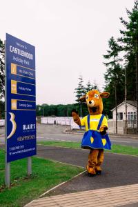 a person in a costume standing next to a sign at Castlewood Holiday Park in Antrim