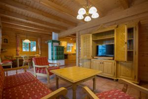 a living room with a table and a television at Feriendorf Koralpe Chalet Gamssprung in St. Gertraud