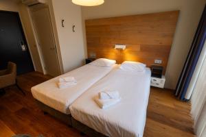 Postel nebo postele na pokoji v ubytování Stadshotel Doesburg