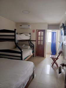 ein Zimmer mit drei Etagenbetten und einer Tür in der Unterkunft Hotel Rumbo al Sol in Playas + 29 Fotos