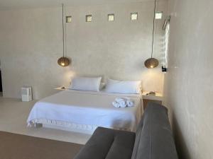 Un dormitorio con una cama blanca con toallas. en Villa Cayetano, en Mahahual