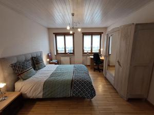 a bedroom with a bed and a desk and windows at Gîte du Verre au Sabot 5 étoiles avec spa privatif in Soucht