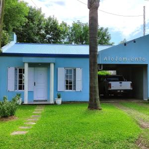 una casa blu con un albero di fronte di Alojamiento Dimar a Villa Elisa