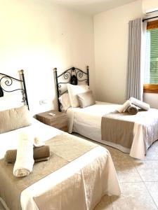 a hotel room with two beds and a window at Villa Tonia in Cala en Blanes +42 photos