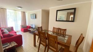 a living room with a table and a red couch at departamentos tres habitaciones in La Serena