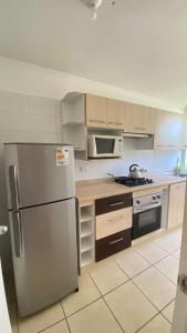 a kitchen with a stainless steel refrigerator and microwave at departamentos tres habitaciones in La Serena