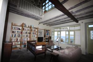 sala de estar con sofá, escritorio y libros en Apollonos Seafront Apartment, en Ermoupoli