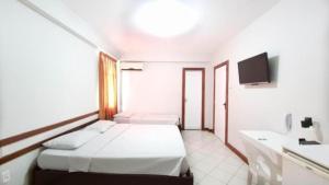a hotel room with two beds and a tv at Pousada Central in Feira de Santana