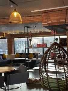 a room with tables and chairs and a hanging chair at Mgzavrebi 10 in Bakuriani
