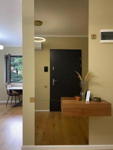 a hallway with a black door and a table at Ophir Apartment Ultracentral,the greenest and brightest central area,3 parking space in the large yard in Cluj-Napoca