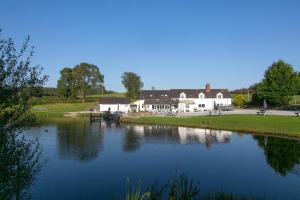 a large house on the side of a lake at Harrison's Cottage in Llandegla