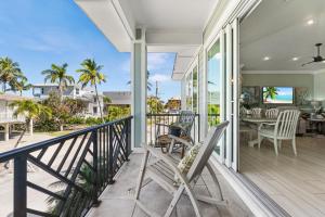 a porch with chairs and a table with a view of the ocean at Close to the Beach, Heated Pool and Spa - Sweet Carolina - Roelens in Fort Myers Beach