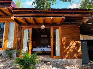 a wooden pergola with a bed inside of it at Hotel Cabañas y Glamping Punta Surf in Brisas de Zicatela