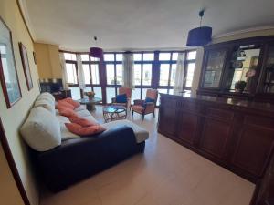 Piso grande en LLANES con garaje في يانس: غرفة معيشة مع أريكة وبعض الكراسي