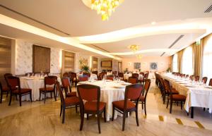 a banquet room with tables and chairs and a chandelier at Grand Hotel Olimpo in Alberobello