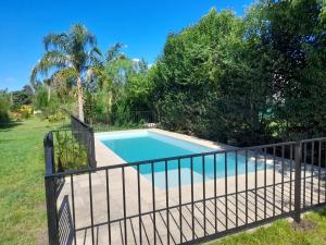 a swimming pool with a fence around it at Oasis del sauce in Paraná