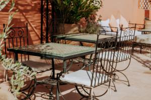 a group of tables and chairs with plants at Riad Bamaga in Marrakesh