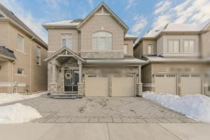 a house with two garage doors on a driveway at 2 Bedroom Private Suite-Parking-Near Hospital and Airport in Oakville