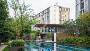 ein Hotel mit einem Swimmingpool vor einem Gebäude in der Unterkunft nap nap like home 2 in Sathani Khlong Rian