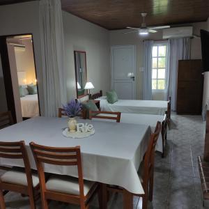 una sala da pranzo con due letti e un tavolo con sedie di Alojamiento Dimar a Villa Elisa