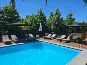 a swimming pool with lounge chairs and umbrellas at Casa Calfu in Santa Cruz