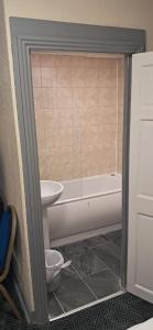 a bathroom with a toilet and a tub and a sink at Park hotel in Bradford