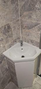 a white sink in a bathroom with tile walls at Park hotel in Bradford