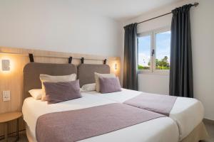 sypialnia z dużym białym łóżkiem i oknem w obiekcie Apartamentos Santa Rosa w Costa Teguise +32 zdjęcia