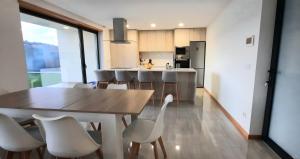 a kitchen with a wooden table and white chairs at Sunny Haven-Villa in Ponte de Lima