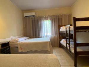 a bedroom with two bunk beds and a window at Aconchego - Casa 3/4 - ar condicionado nos 3/4 -garagem in Palmas