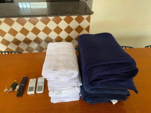 a wooden table with towels and a remote control at Aconchego - Casa 3/4 - ar condicionado nos 3/4 -garagem in Palmas +31 photos