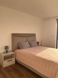 a bedroom with a large bed and a night stand at Sunny Haven-Villa in Ponte de Lima