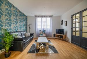 a living room with a couch and a table at Maison d exception au Mans Garage XXL et Terrasse in Le Mans