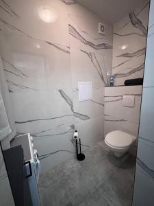 a bathroom with a toilet and a marble wall at Top výhľad !-Apartmán 10-Nová Lesná in Nová Lesná