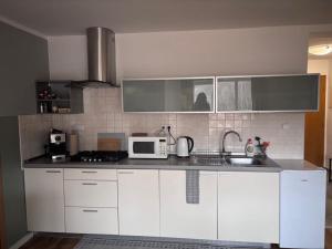 a kitchen with white cabinets and a microwave at Top výhľad !-Apartmán 10-Nová Lesná in Nová Lesná +16 photos