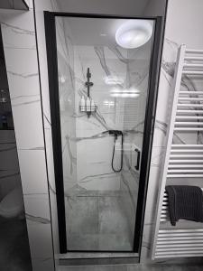 a shower with a glass door in a bathroom at Top výhľad !-Apartmán 10-Nová Lesná in Nová Lesná