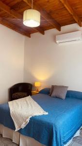 a bedroom with a blue bed and a chair at La Talita in Colón +12 photos